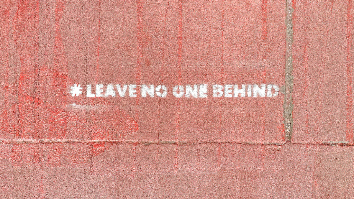 Bild des Schriftzuges "leave no one behind" auf einer roten Wand © Etienne Girardet, unsplash.com