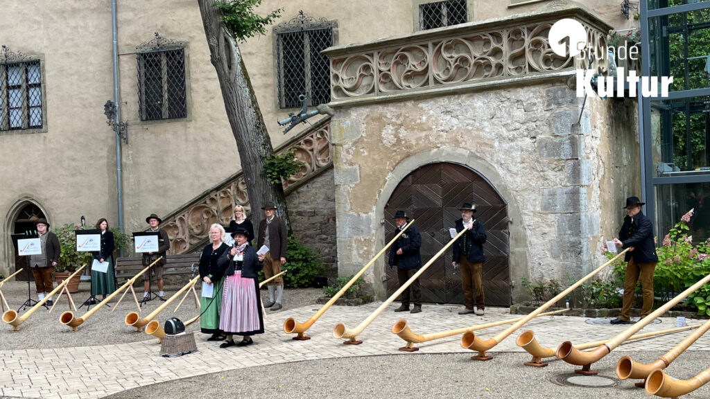 Alphornbläser im Innenhof eines Schlosses