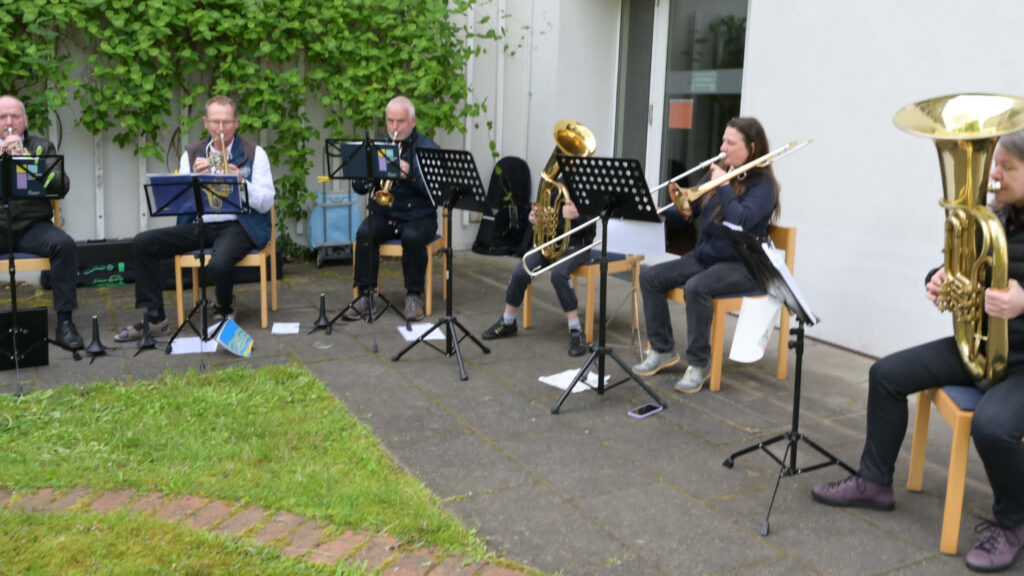 Bild mit Menschen, die ein Blechblasinstrumente spielen