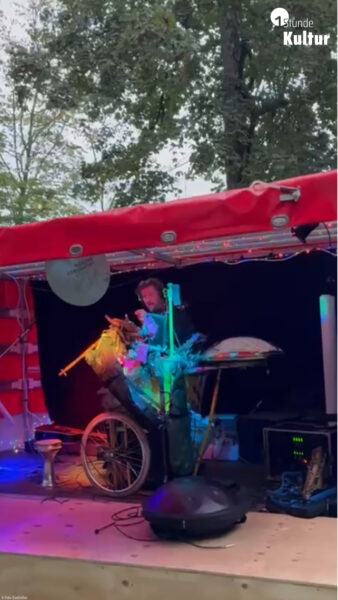 Ein Musiker, der auf eigenen individuell gebauten experimentellen Instrumenten auf einer Bühne spielt