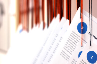 Bild mit Papierblättern, die an bunten Schnüren hängen