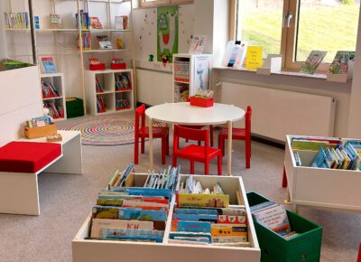 Innenansicht mit Bücherkisten, Regalen und Sitz- und Spielmöglichkeiten