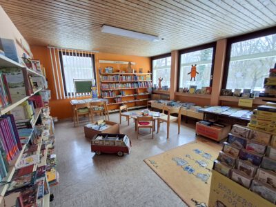Innenansicht Familienbücherei mit Bücherregalen, Bücherkisten und Sitzmöglichkeiten