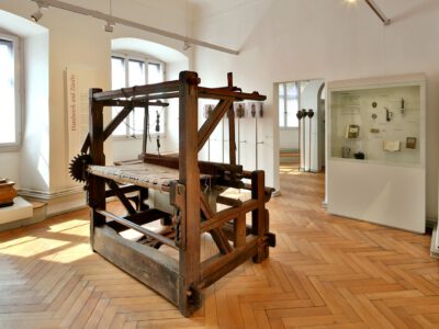 Ausstellungsraum im Henneberg-Museum mit altem Webstuhl