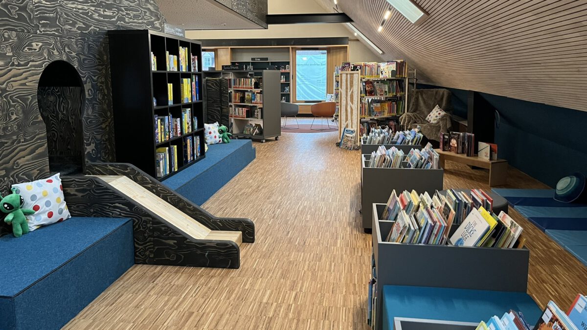 Kinderbereich der Stadtbibliothek Hammelburg mit Bücherregalen und kleiner Rutsche
