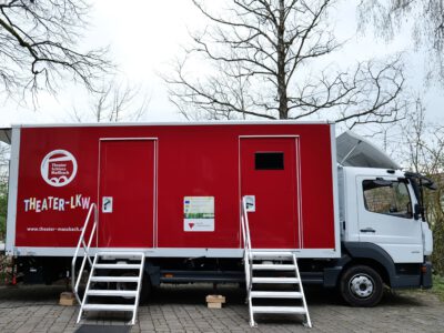 Roter Theater-LKW mit Bühnen- und Zuschauereingang