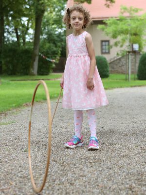 Ein Mädchen spielt mit einem Reifen aus Holz.