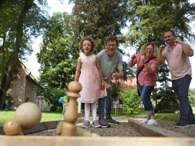 Eine Familie mit 4 Personen spielt Schach im Freien.